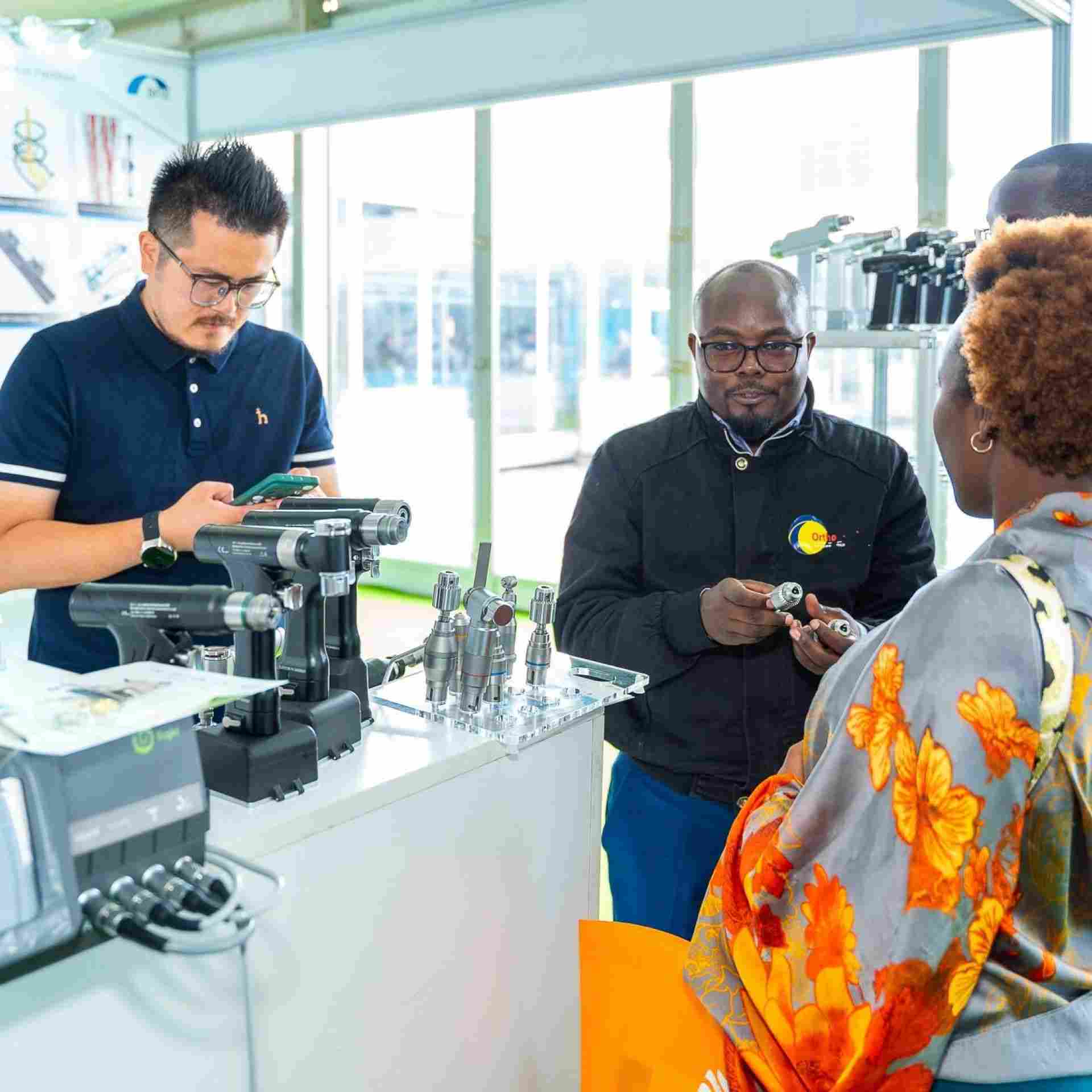  Exhibitors showing a medical device to attendees at World Health Expo Nairobi
