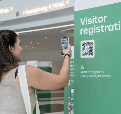 Visitor checking in scanning a QR code.