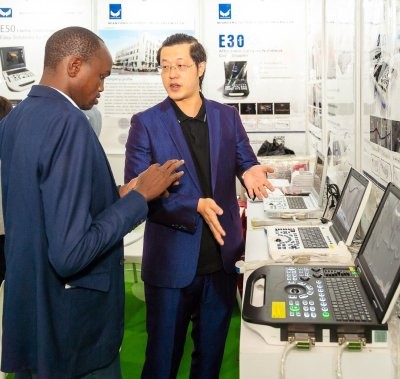An exhibitor explaining a new product to an attendee at World Health Expo Labs Nairobi